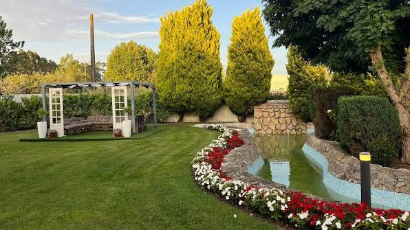 Zona de lounge no jardim com gazebo e lago de flores